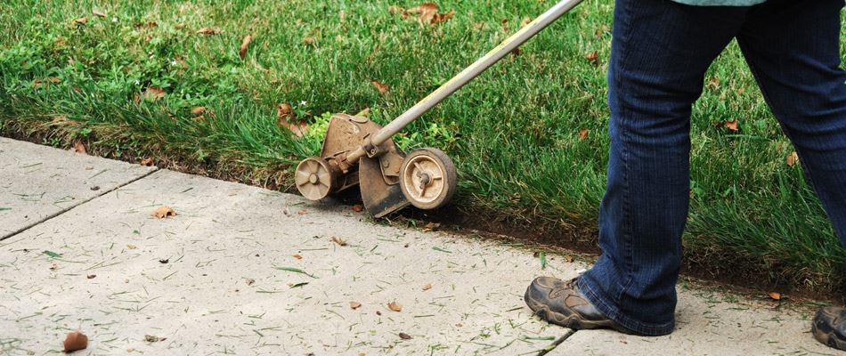 String trimmer edging lawn after being mowed in Lake Worth, TX.